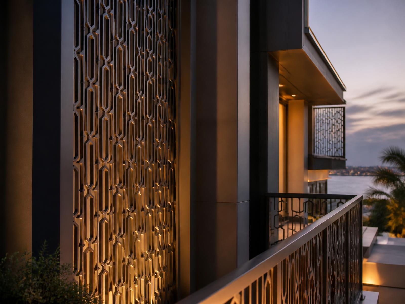 Matte black and champagne bronze powder-coated aluminum screens on a modern waterfront residence